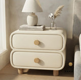 Modern cream upholstered nightstand positioned on the left side of a contemporary textured fabric bed in a luxury bedroom.