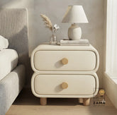 Premium two-drawer soft-edge bedside table styled on the right side of a neutral luxury bed with a minimalist lamp.