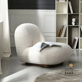 Zama Home Store white bouclé accent chair with an open book resting on the seat, positioned near a modern bookshelf in a bright room.