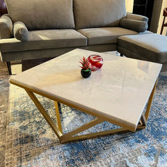 Gray sectional sofa with a marble coffee table in a living room setting.