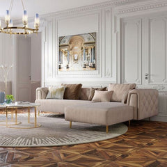 Modern living room with a beige sofa, decorative pillows, and a large painting on the wall.