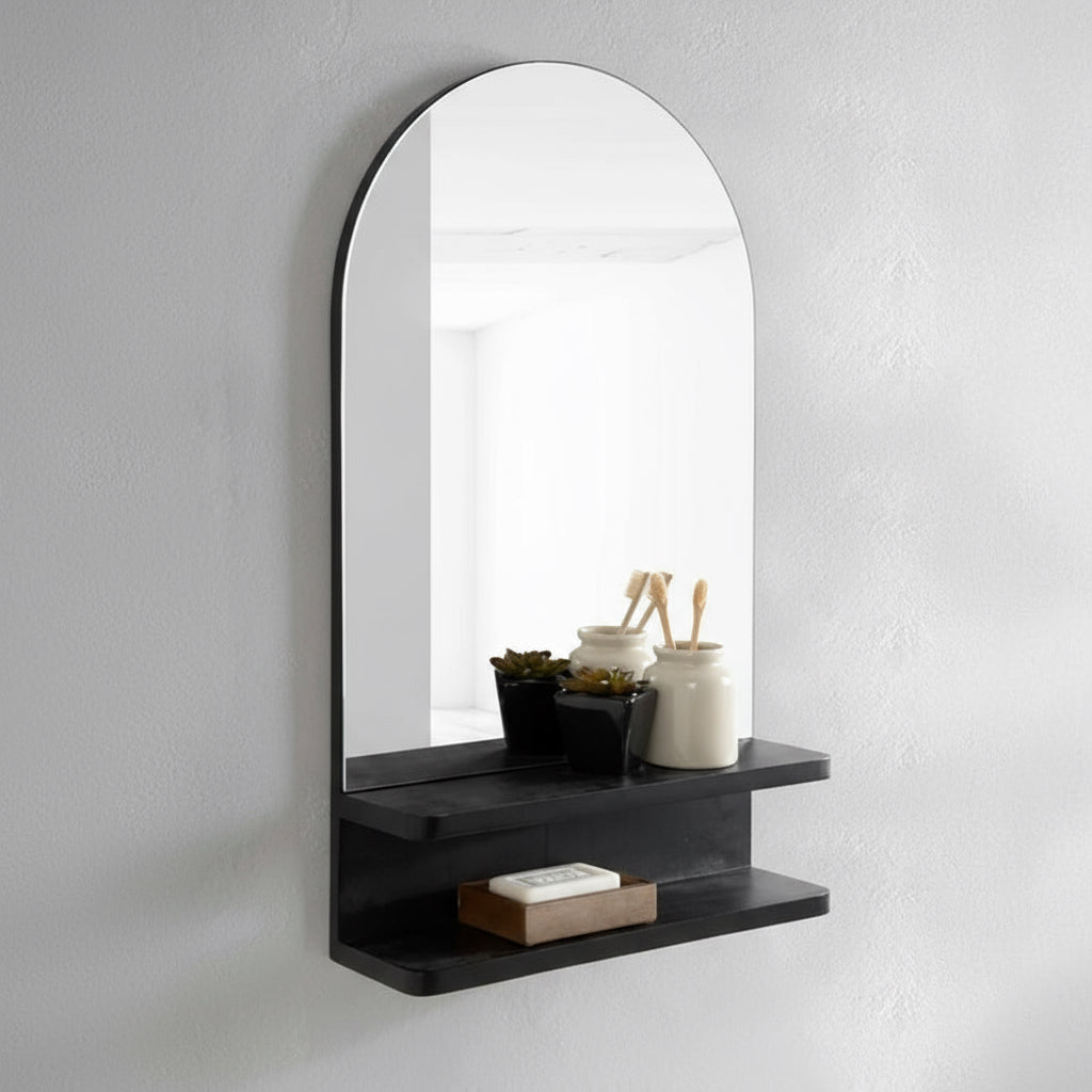 Arched mirror with a black shelf on a white wall