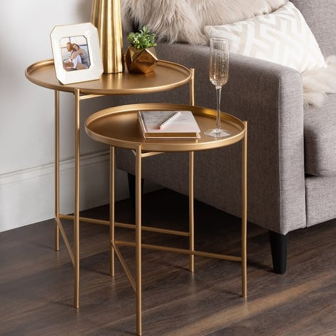 Gold side table with decorative items next to a gray sofa.