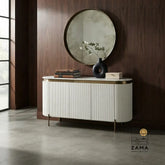White fluted credenza with brass accents placed against a warm wood panel wall.
