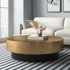 Gold coffee table with a vase of flowers in a living room setting
