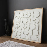 CERCLE Wall Art leaning on the floor showing its textured white geometric circle pattern.