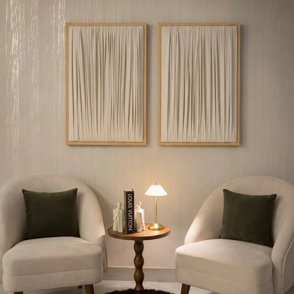 ETOFFE Wall Art set with cream draped fabric in light wood frames hanging above chairs.