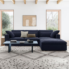 Modern living room with a dark blue sectional sofa, coffee table, and decorative pillows.