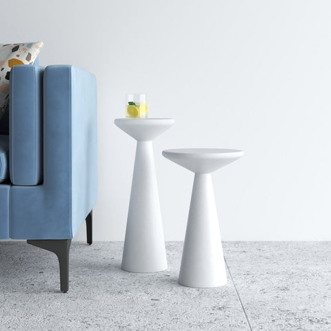 Two modern white side tables in a living room setting with a blue sofa.