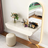 Modern vanity table with mirror, stool, and decorative items in a room.