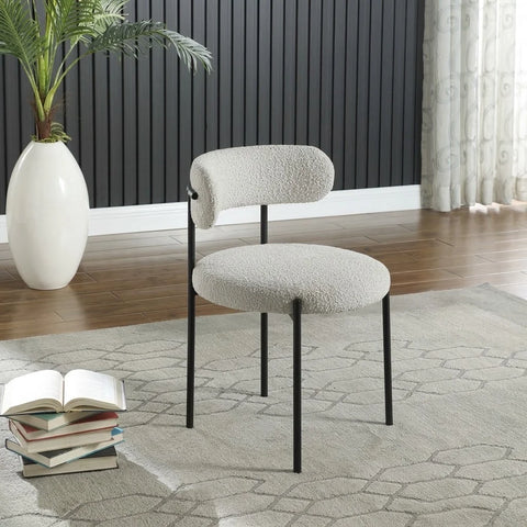 Elba dining chair with cream boucle fabric by Zama Home Store against a black paneled wall