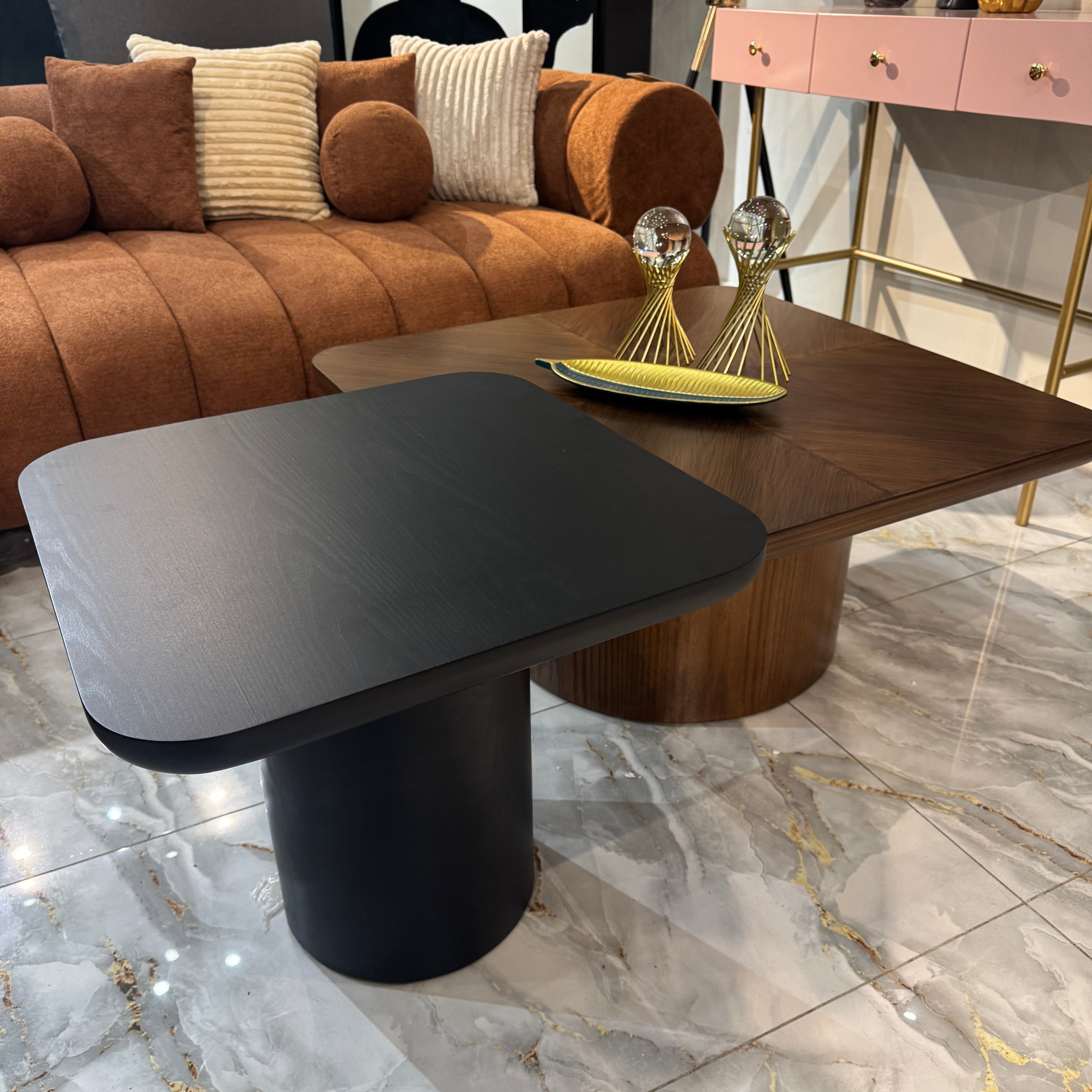 Modern living room with a brown sofa, black and gray side table, and marble floor.