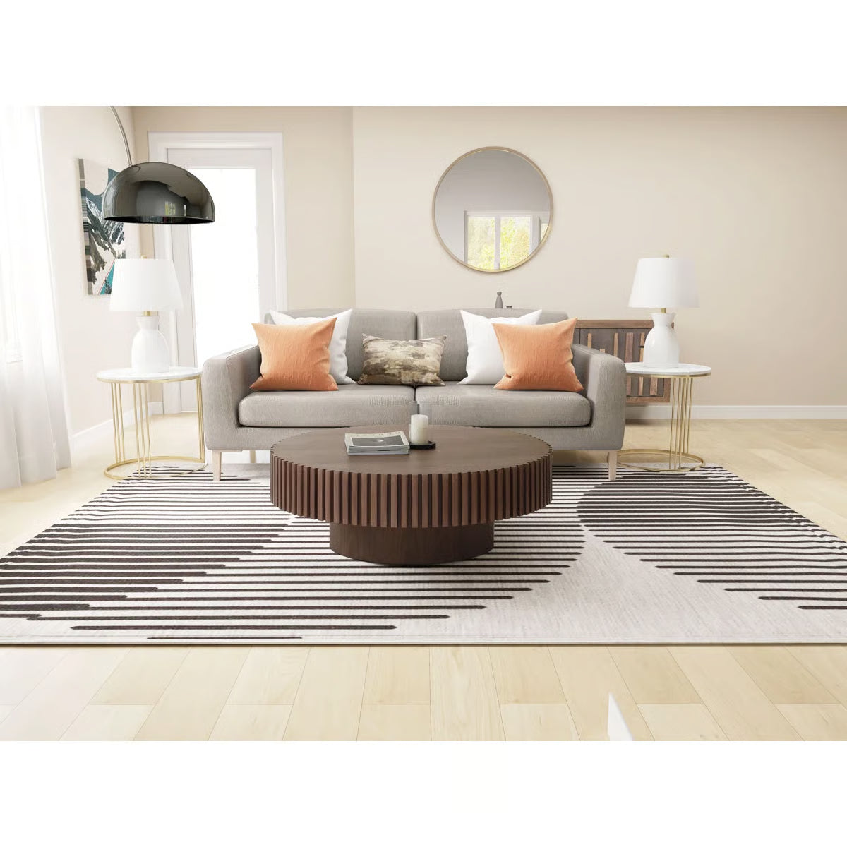 Modern living room with a gray sofa, round coffee table, and striped rug.
