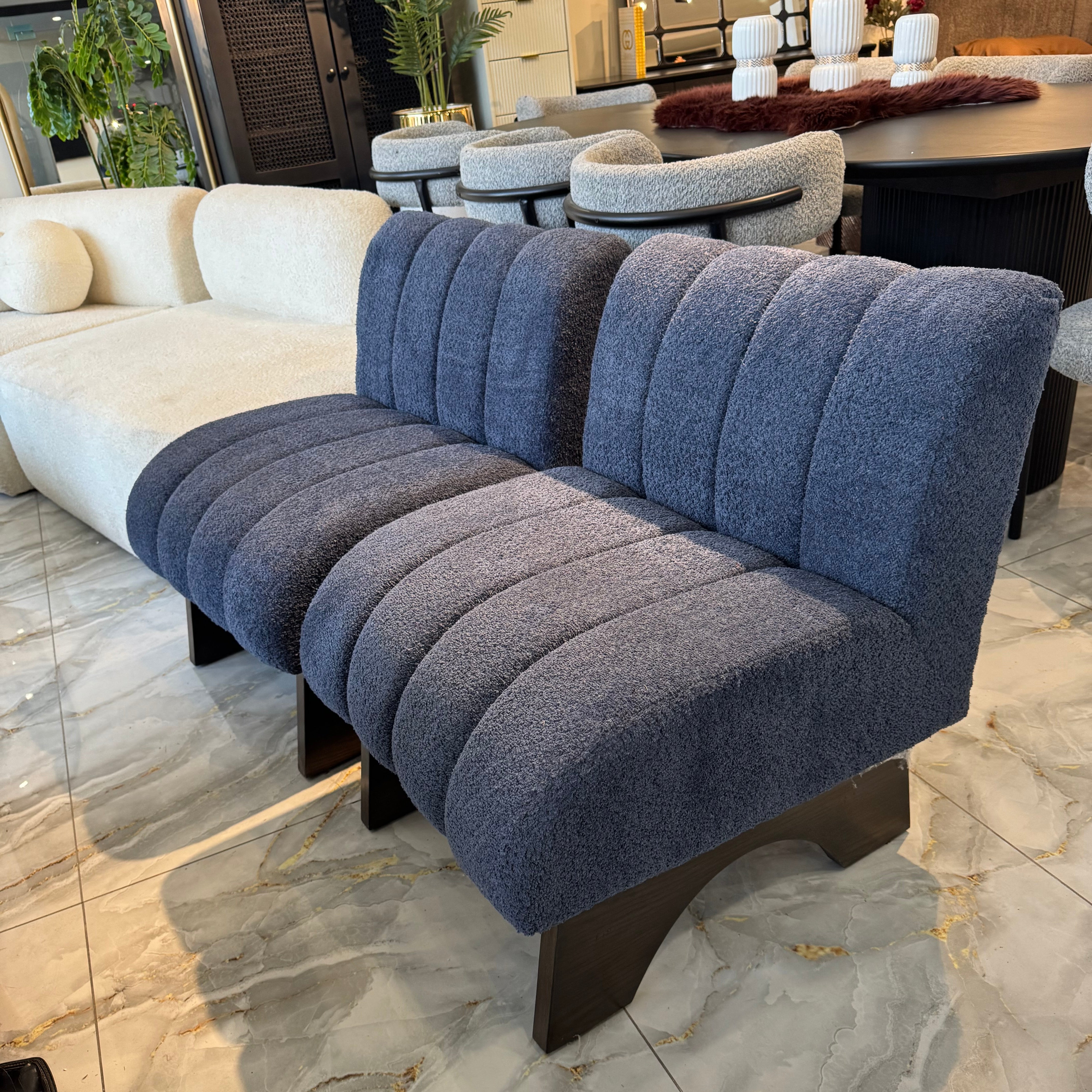 Beige textured sofa with wooden legs on a marble floor