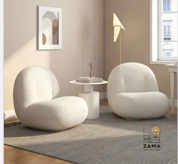 Cozy living room corner with two Zama Home Store white bouclé lounge chairs and a round side table on a textured rug.