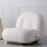 Three-quarter view of the Zama Home Store white bouclé lounge chair showing its plush, curved, armless design on a dark metallic base.