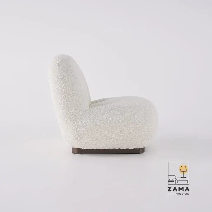 Side profile view of the Zama Home Store white bouclé armchair, clearly showing its low-profile, ergonomic curve and dark wooden base.