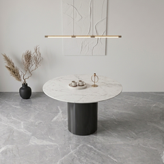 Modern dining table with marble top and black base in a minimalistic room.