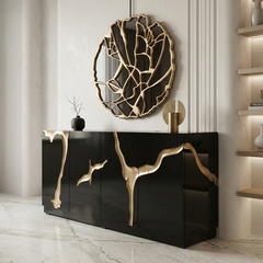 Modern interior with a black cabinet featuring gold leaf designs, a decorative wall mirror, and a small plant.