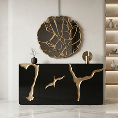 Modern black and gold sideboard with decorative wall mirror in a stylish interior setting.