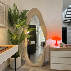 Modern interior design with a large floor mirror, potted plant, and desk.