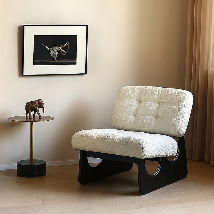Modern chair in a room with a side table and framed artwork on the wall.
