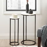 Two small round tables with black metal legs and white marble tops in a room with a window.