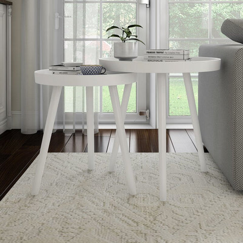 White side table with decorative items in a living room setting