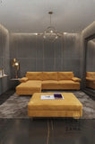 Zama Home Store mustard velvet sectional couch with chaise lounge and large ottoman in a luxurious grey living room.