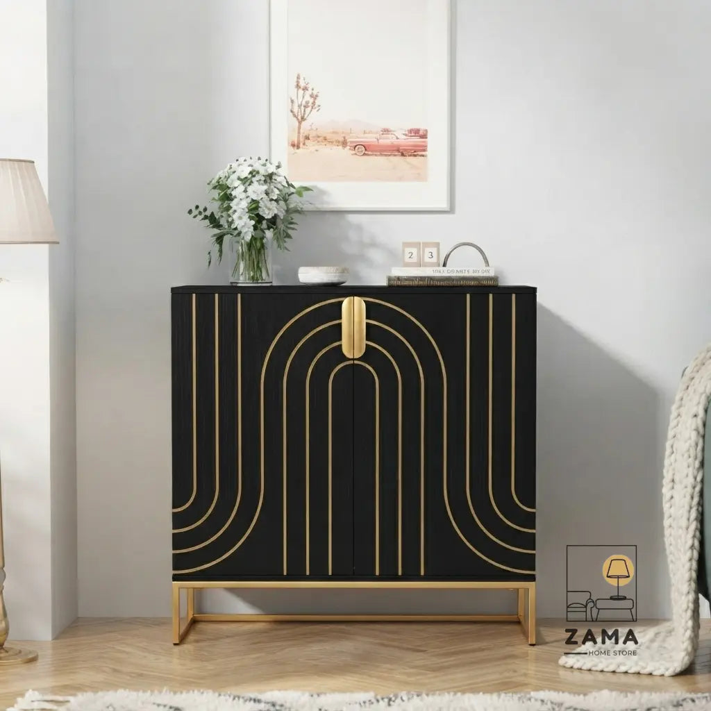 A modern, black wooden buffet console with geometric gold arch patterns and an elevated gold base, styled in an elegant living room with a vase of flowers and framed art on top. Logo for Zama Home Store in the corner.