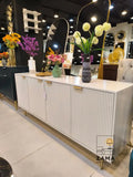 Modern white fluted sideboard by Zama Home Store on display in a showroom setting.