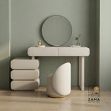 Modern cream curved vanity table set with integrated round mirror and matching upholstered stool, perfectly centered in a luxury dressing room with warm wood paneling.