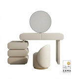 Front view of a contemporary dressing table with smooth rounded edges, featuring a unique pill-shaped stacked drawer unit and a minimalist round mirror in a matte off-white finish.