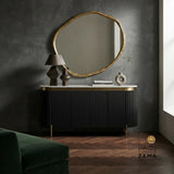 Black and gold modern sideboard featuring vertical reed detailing against a dark wall.