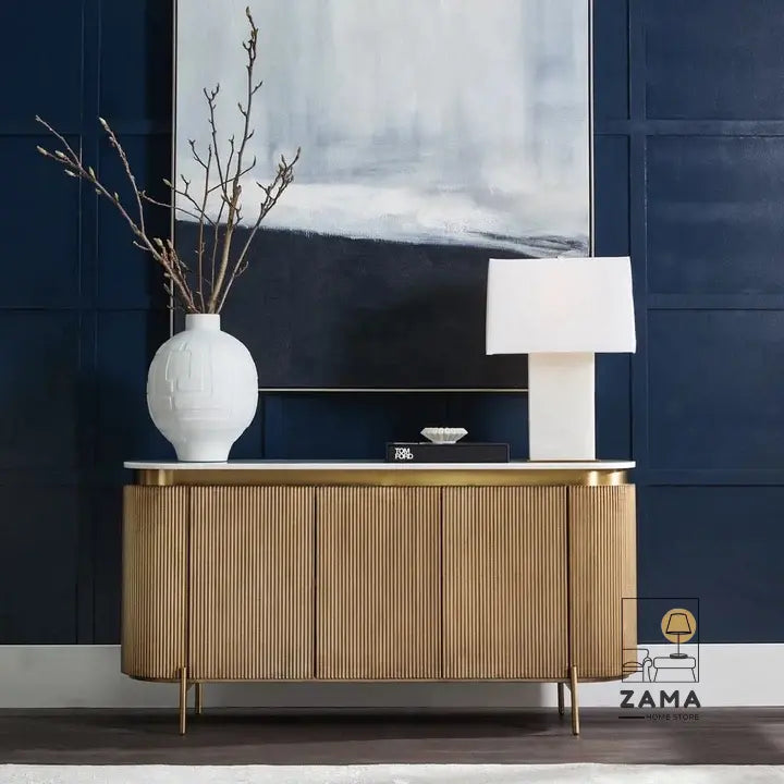 Front view of a luxury gold reeded buffet cabinet in a dark blue interior setting.