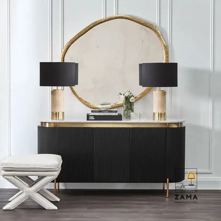 Modern black storage console paired with marble table lamps and an organic wall mirror.