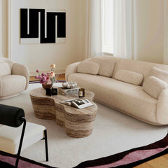 Modern living room with beige sofa, coffee table, and decorative elements.