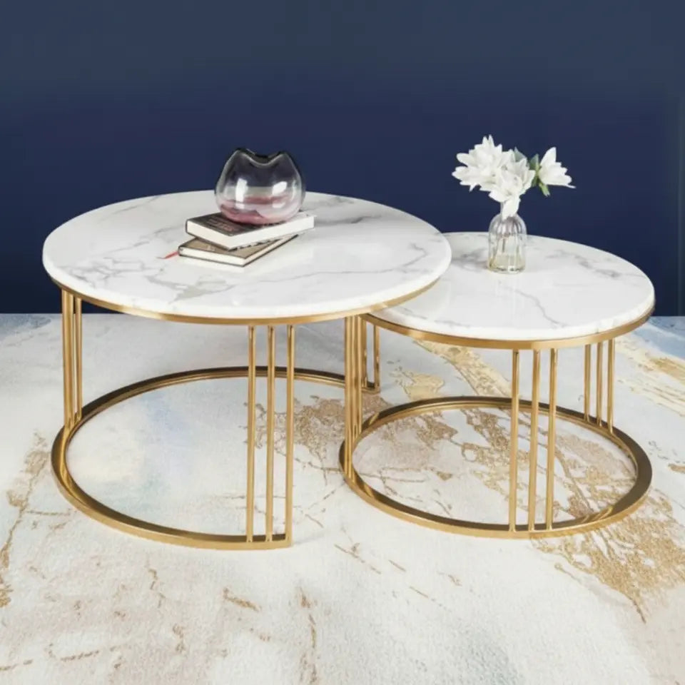 Two marble coffee tables with gold frames on a light-colored floor.