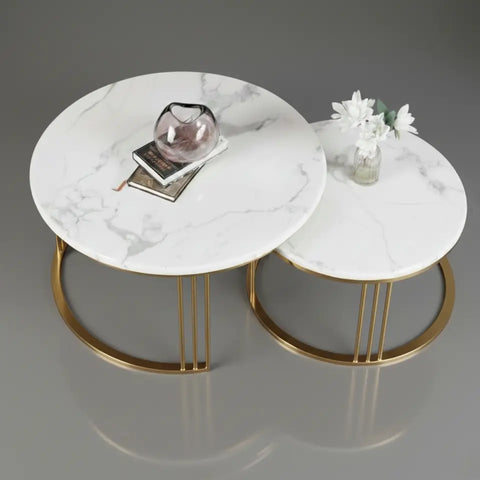 Two marble coffee tables with gold legs on a gray background