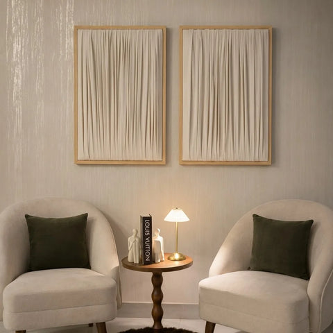 ETOFFE Wall Art set with cream draped fabric in light wood frames hanging above chairs.