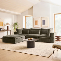 Modern living room with a gray sectional sofa, coffee table, and decorative elements.