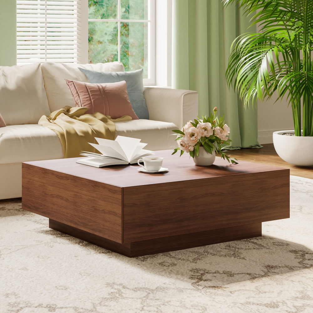 Living room with a wooden coffee table, book, cup, and flowers.