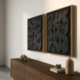 Angled view of NERO Wall Art showing black raised geometric shapes above a dark wood cabinet.