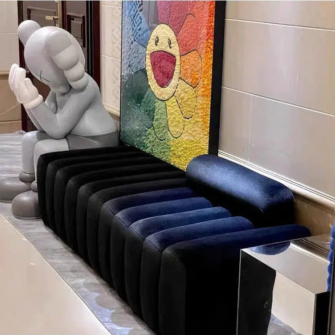 Row of colorful inflatable chairs in a room with a decorative wall art piece.
