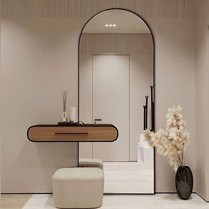 Modern bathroom interior with a large mirror, wooden vanity, and decorative elements.