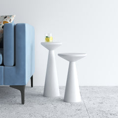 Two modern white side tables in a living room setting with a blue sofa.