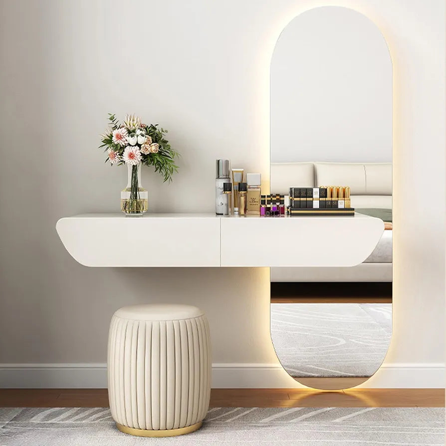 Modern vanity setup with a mirror, stool, and decorative items on a white wall.