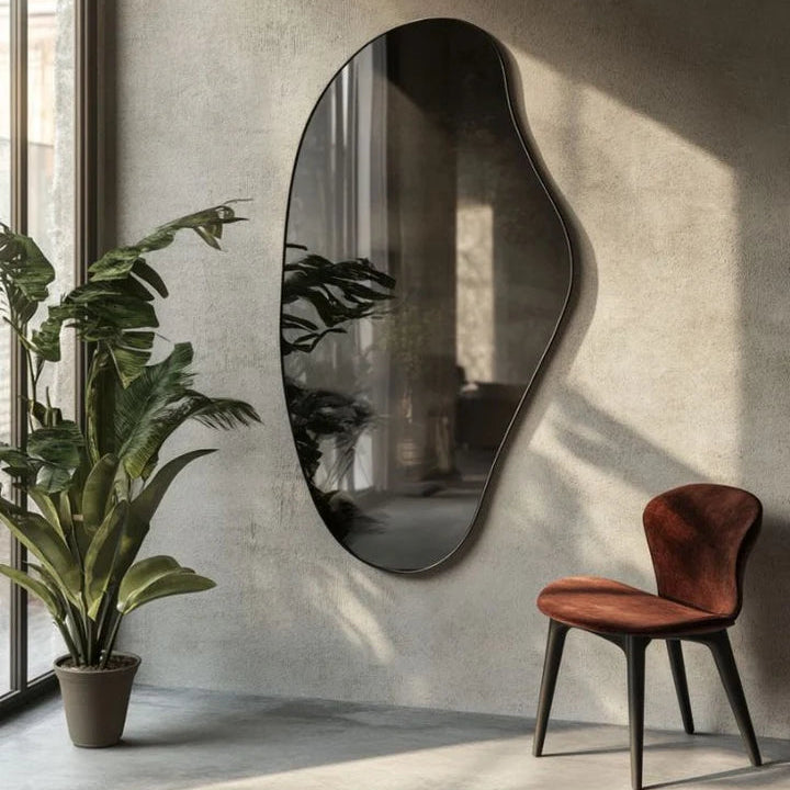 Modern interior with an oval mirror, plant, and chair against a textured wall.