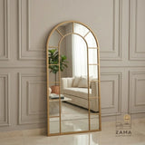 Arch top grid standing mirror by Zama Home Store leaning against a beige wall in a luxury room