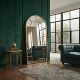 Arch top grid standing mirror by Zama Home Store styled against a green wall with a leather sofa